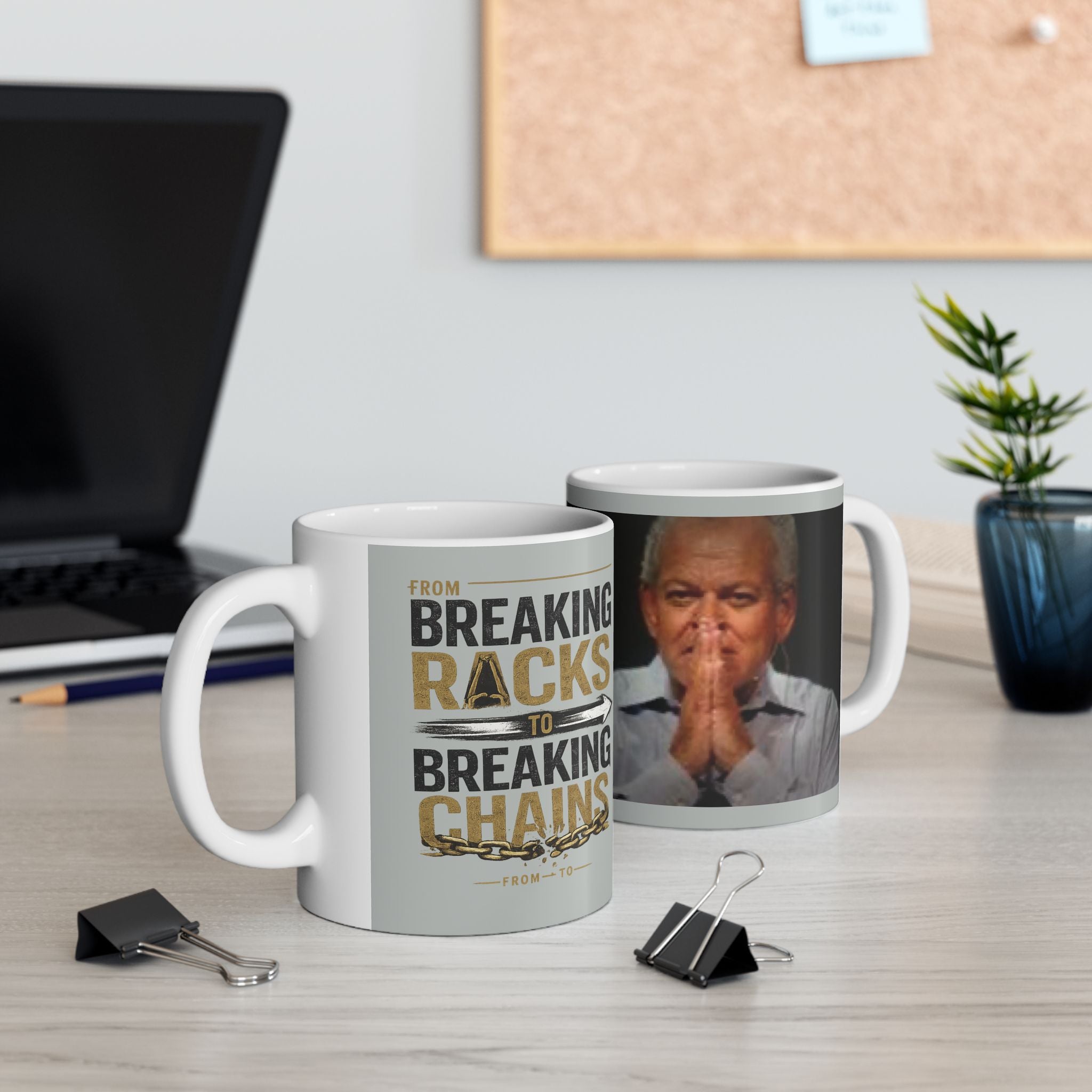 Two mugs on a desk with one featuring a motivational quote and the other with a photo of a person.