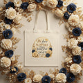 Beige tote bag with floral design surrounded by a flower wreath background with We Love and Support Johnny and Janet for Life 